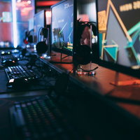並んで置かれたゲーミングPCのモニターとキーボード（eスポーツ施設「CGA」内）の写真