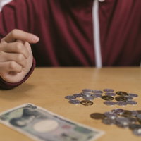 いくら数えてもお金が足らない子ども、小銭と紙幣を数えるの写真