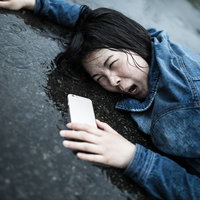 水たまりにズコーッと転倒する女性のアクシデントの写真