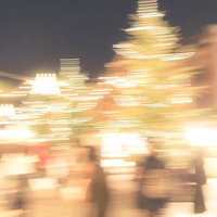 人混みに映るイルミネーションの光跡と夜間の商業施設の写真