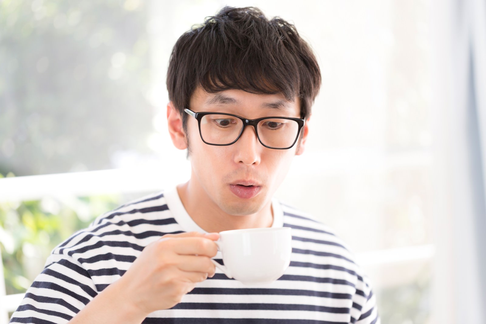 サードウェーブコーヒーに驚く眼鏡の男性［モデル：大川竜弥］