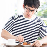 サードウェーブ系男子がドーナッツとコーヒーで休日を過ごすの写真