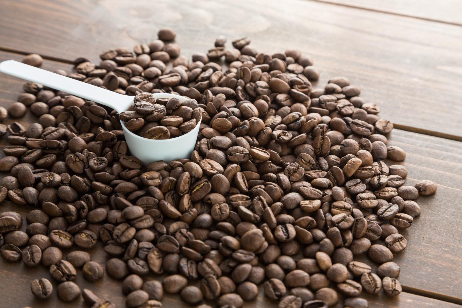 白いスプーンでコーヒー豆を計量