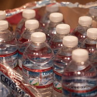 備えていた大量の飲料水を開封、ペットボトルがケースに整然と並ぶの写真
