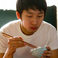 口いっぱいにご飯をもぐもぐ頬張る男性の写真