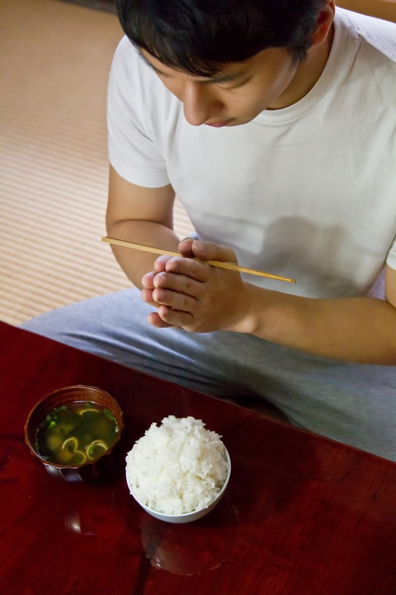 手を合わせてご飯を頂きますする男性［モデル：大川竜弥］