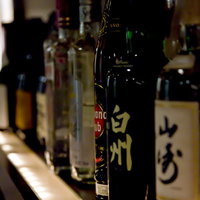 バーのカウンターに並べられたお酒のボトルの写真