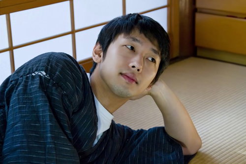 甚平姿で和室の畳に寝転ぶ男性