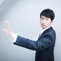 後ろを歩く美人社員に左手の薬指を見せ未婚をアピールする独身貴族の写真