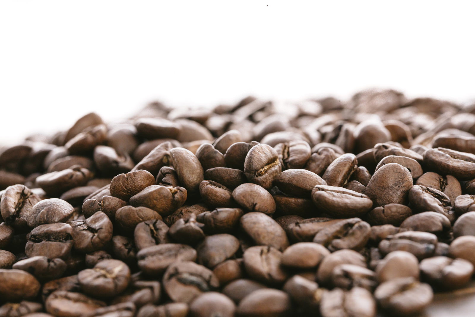 白い背景に積み重なった焙煎コーヒー豆