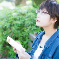 実写化のキャストを想像しながら小説を読むメガネ女子の写真