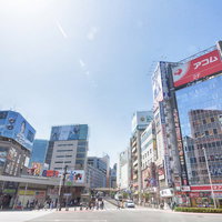 新宿駅前の青梅街道沿いの繁華街の昼間風景の写真