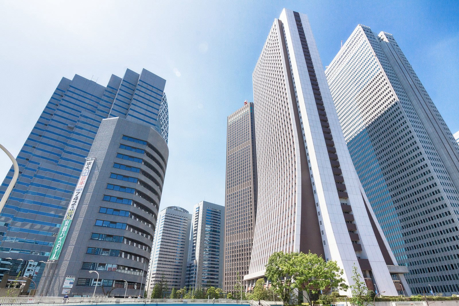 晴れた日の新宿の高層ビル群。複数の高いオフィスビルが青空に向かって立ち並んでいます。
