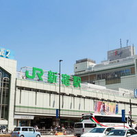 JR新宿駅南口の駅前広場と周辺商業施設の都市風景の写真