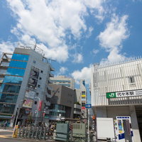 JR山手線代々木駅前の駅舎とビル街、歩行者が行き交う都市風景の写真