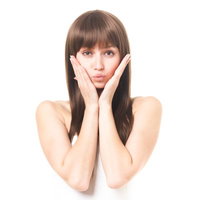 両手を頬に添えるロングヘアの女性の美容ポートレートの写真