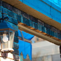 暖かい光を灯すレンガでできた店先の街灯の写真