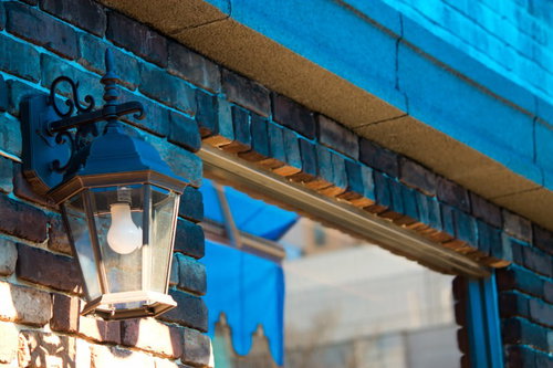 暖かい光を灯すレンガでできた店先の街灯