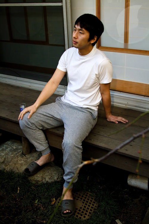 甚平姿で縁側の庭でくつろぐ男性