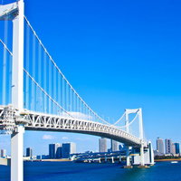 水面に反射するライトアップされたレインボーブリッジの写真