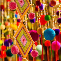 天井から吊るされたカラフルなポンポンの飾りの写真