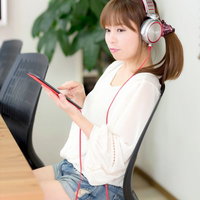 ヘッドホンでタブレットの音楽を聴く女性の写真