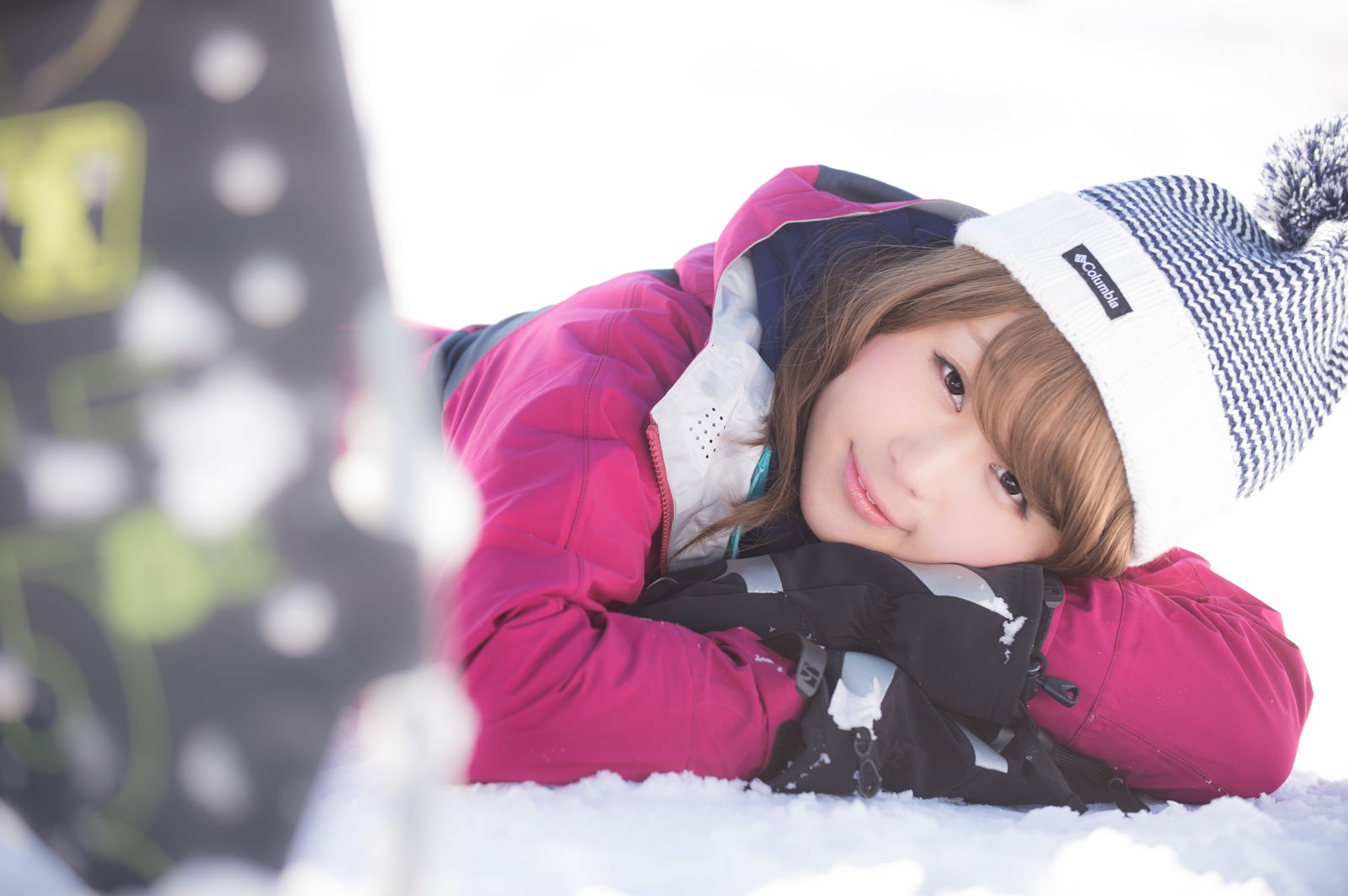 雪の上に寝転びカメラに微笑む女性［モデル：茜さや］