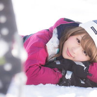 雪山を歩き疲れた都会女子が雪に寝転んで微笑むの写真