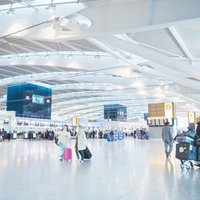 広い空間に旅行者が行き交うヒースロー空港のロビーの写真