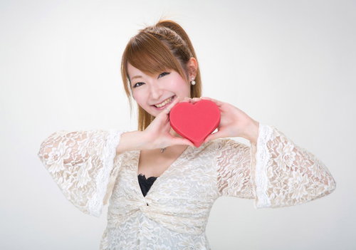 赤いハート型の小箱を持つレース衣装の女性