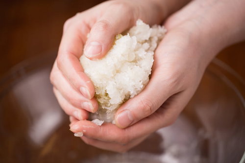 すりおろした大根の水気を手で絞り取る調理工程