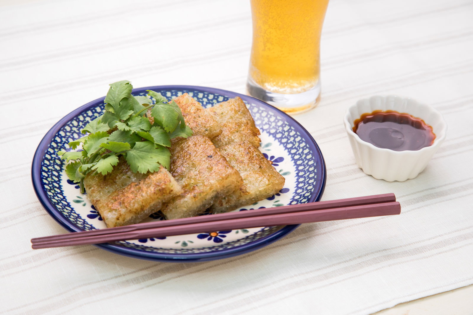 青い模様の皿に盛った揚げ大根もちと香菜、ビール