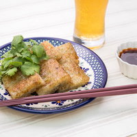 揚げた大根もちにビールと香菜を添えた一皿の写真
