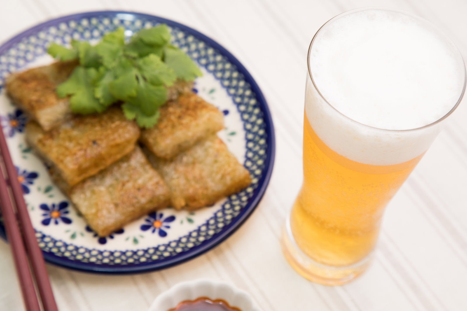 青い模様の皿に盛った大根もちとビール
