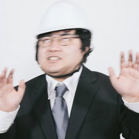 ヘルメットを被ったスーツ姿で冷静さを失う職員の写真