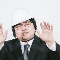 ヘルメットを被り両手で制止のポーズをとる男性職員の写真
