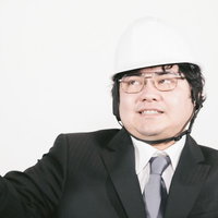 冷静沈着を呼びかけるヘルメットをかぶった男性職員の写真