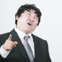 発狂して指を突きつけるスーツの男性の写真