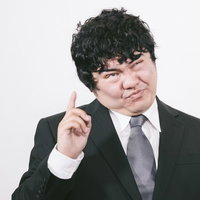 ほげっ！？と驚く表情で力説するスーツ姿の眼鏡をかけた男性の写真