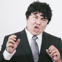 スーツ姿で力説する男性の写真
