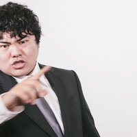 ズバッと指摘するスーツ姿のサラリーマン男性の写真