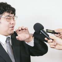 複数のマイクを突きつけられる会社役員の囲み取材の写真