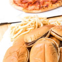 アメリカンファーストフード界のスリートップ、ハンバーガーとピザとポテトフライの写真