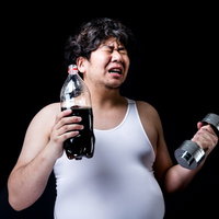 コーラの重さでダンベルの重さを決めるダイエッター男性の写真