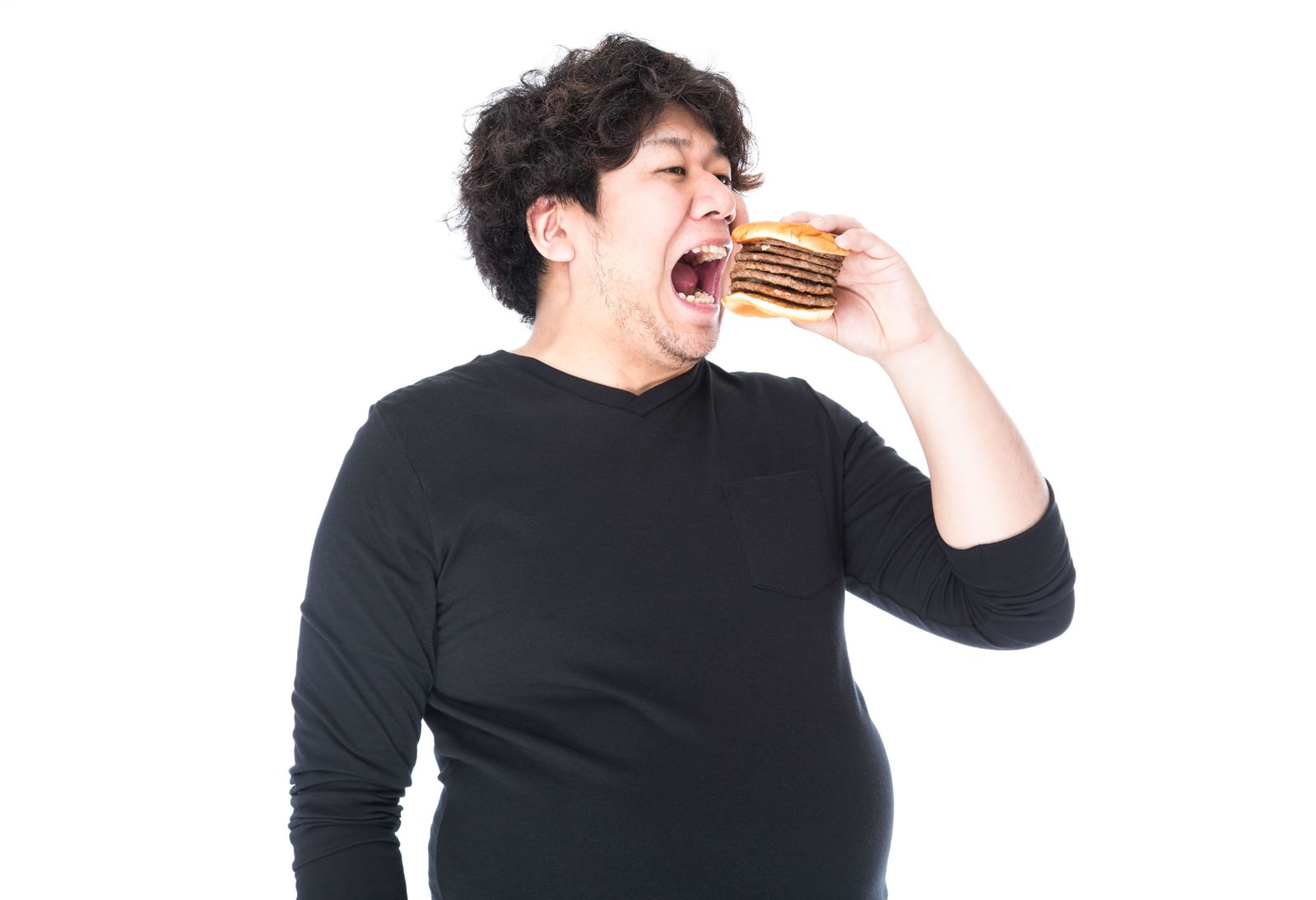 積み重ねたハンバーガーを持ち、大きく口を開ける男性の横顔［モデル：朽木誠一郎］