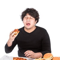 100枚目のピザに疲れ果てた男性の大食いの写真