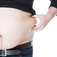 見た目とは裏腹に張りのあるばら肉を摘む男性の写真