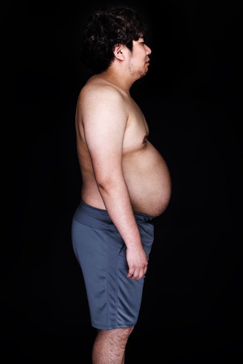 横向きで立つメタボ男性のビフォー写真［モデル：朽木誠一郎］