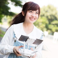 ドローンのコントローラーを操作して笑顔の女性の写真