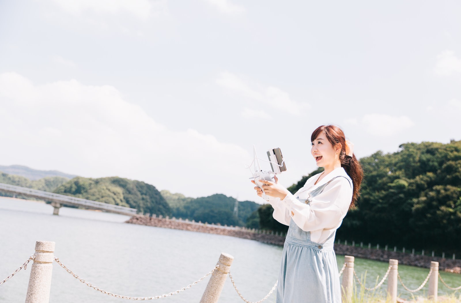伊万里市の川沿いでドローンを持つ女性